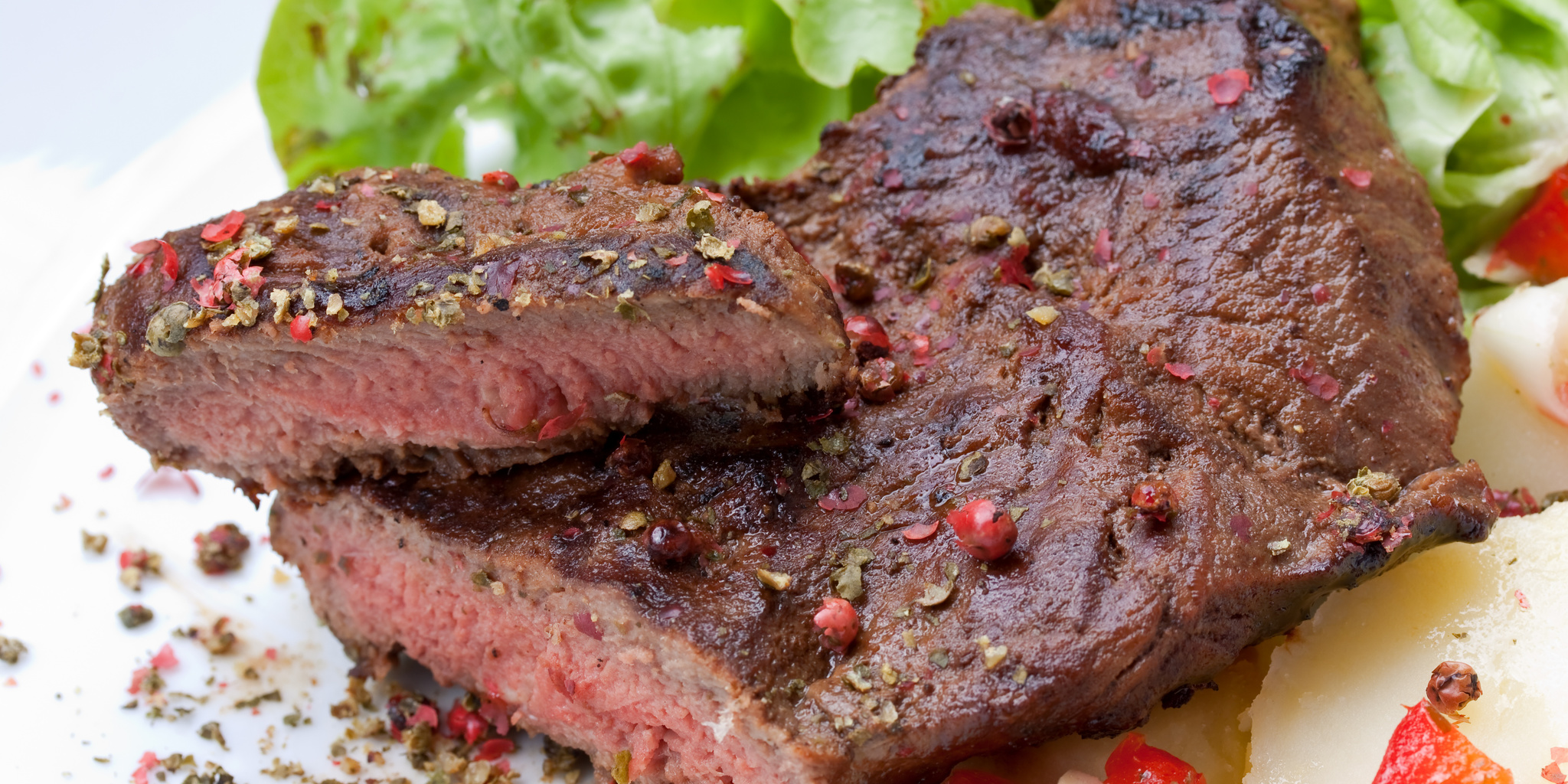 Говядина терияки. Стейк на белом фоне. Мясо тонко нарезанное и замаринованное. Говядина жареное в тарелке. Сырое мясо карпаччо.